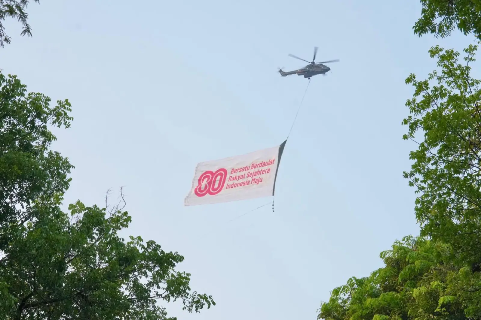 Helikopter membawa bendera merah putih di langit Jakarta